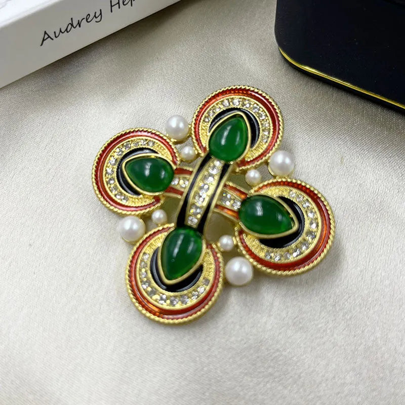 Close-up of a zinc alloy baroque brooch with a central crystal cross in a vintage style.