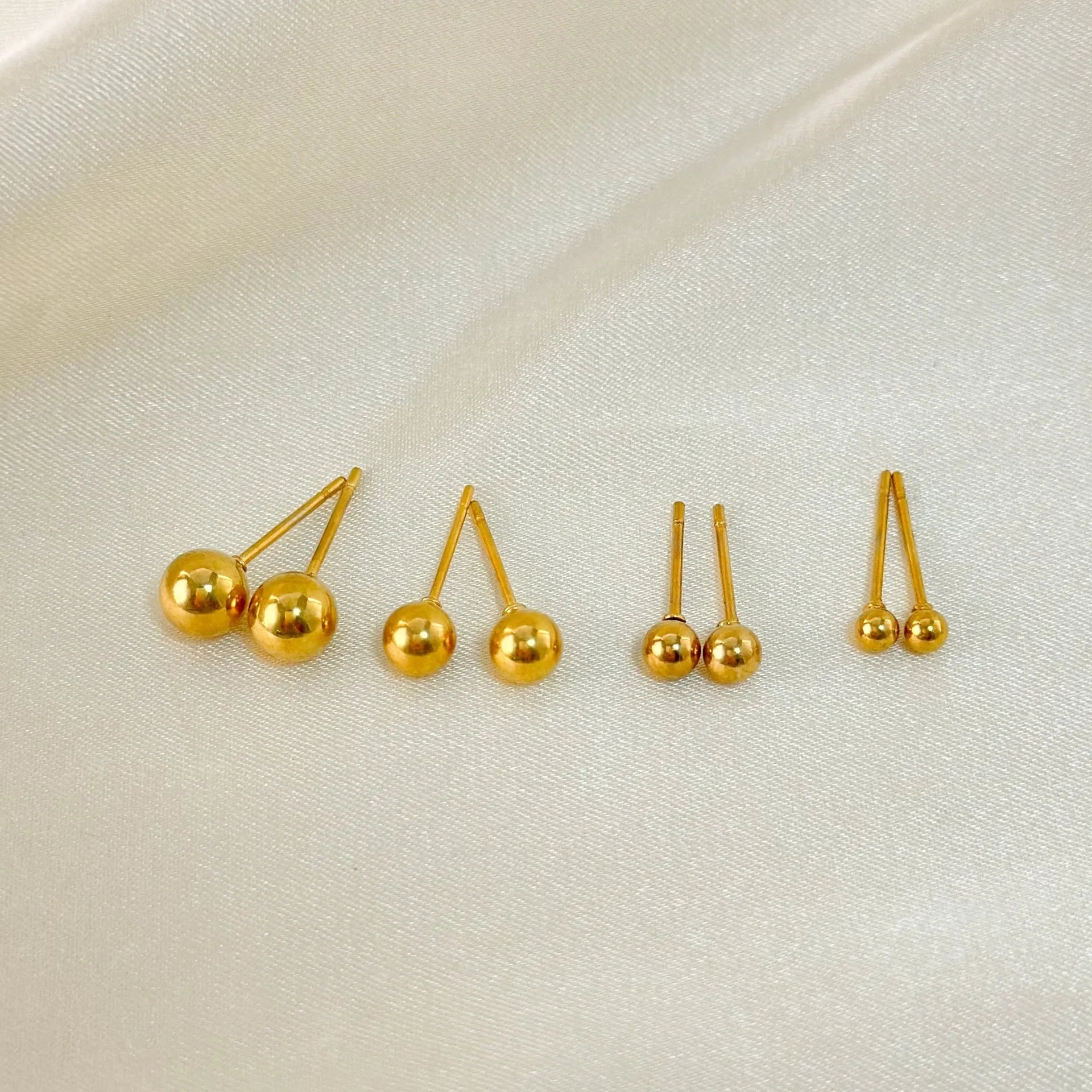 Stainless steel ball stud earrings in gold and silver tones, showing different sizes from 3mm to 6mm.