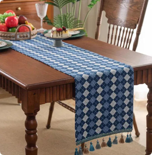 A retro style table flag with handwoven tassels in a blue ginkgo leaf pattern on a table.