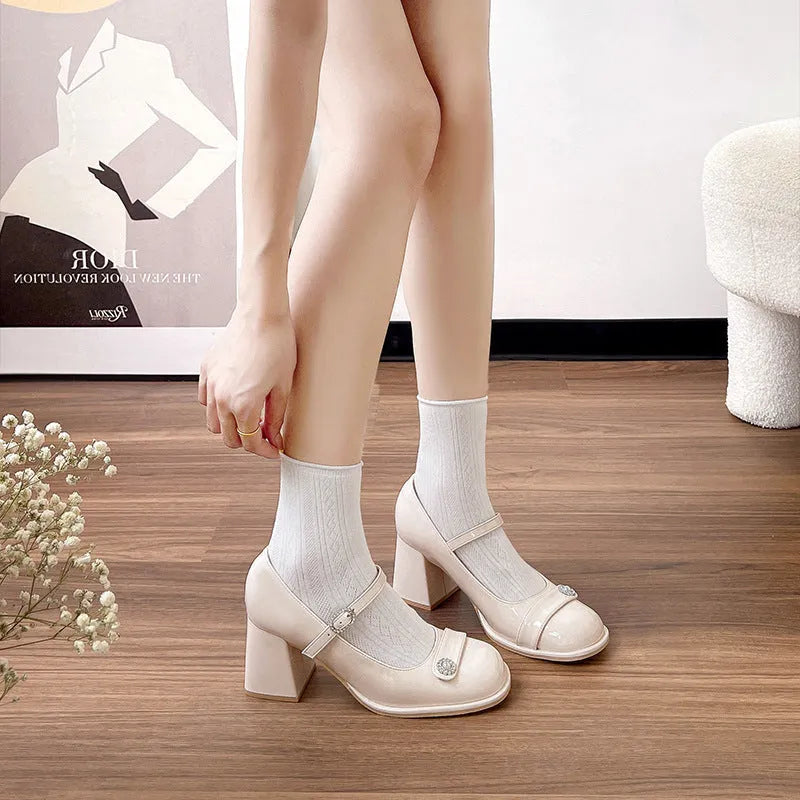 Women's black patent leather chunky heel round toe shoes with buckle fastening.