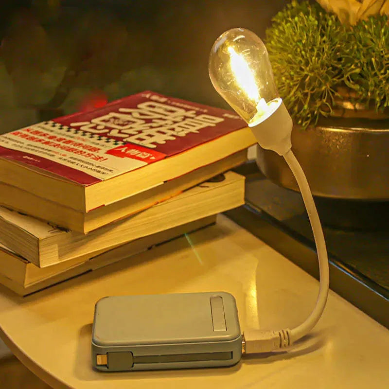 Folding USB rechargeable night light with glowing tungsten filament bulb.