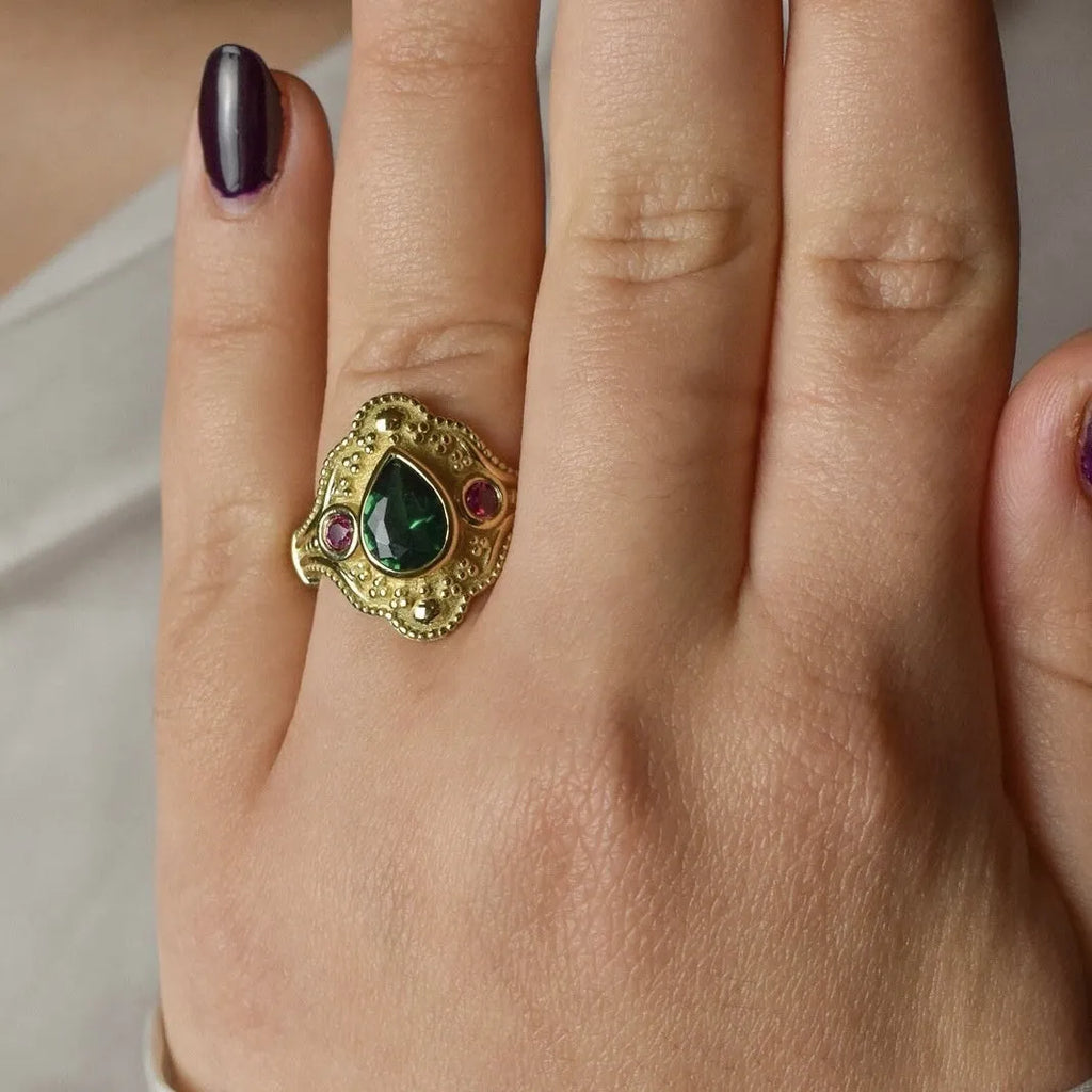 Geometric golden women's fashion ring on a grey background, showing its electroplated alloy construction.