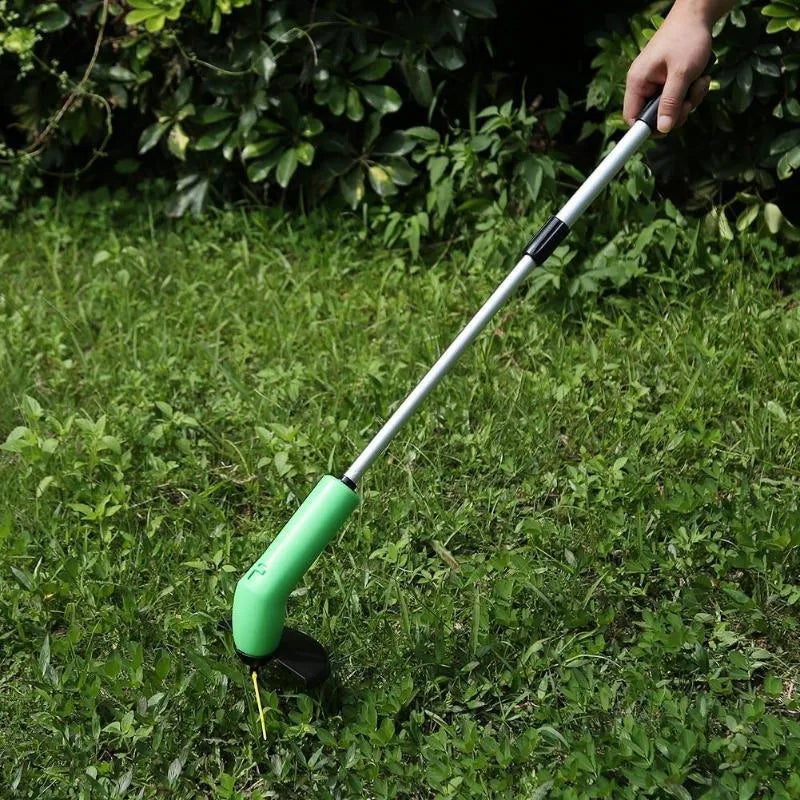 Cordless lawn trimmer with extension pole and protective shield on grass