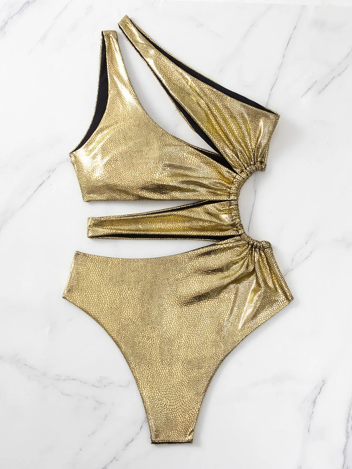 Gold one-piece backless swimsuit for women laid flat, showing sleeveless design.