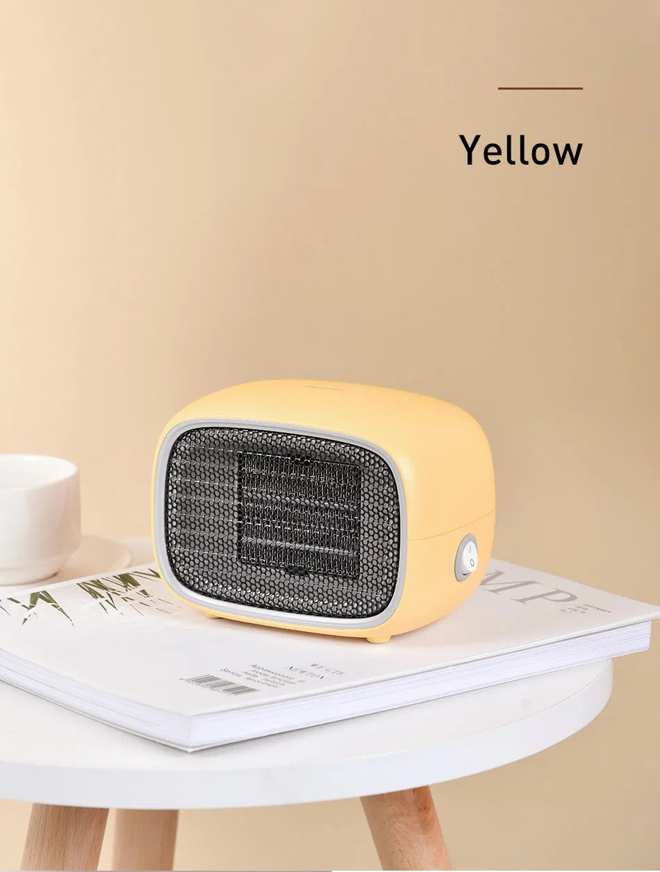 Mini green desktop heater with metal grille showing compact size on a wooden desk