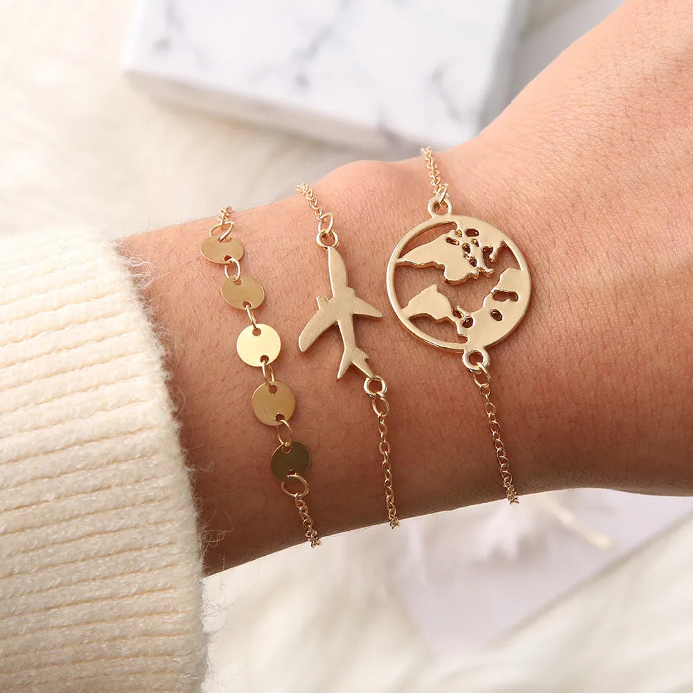 Three bohemian bracelets with heart-shaped aircraft map charms in silver tone