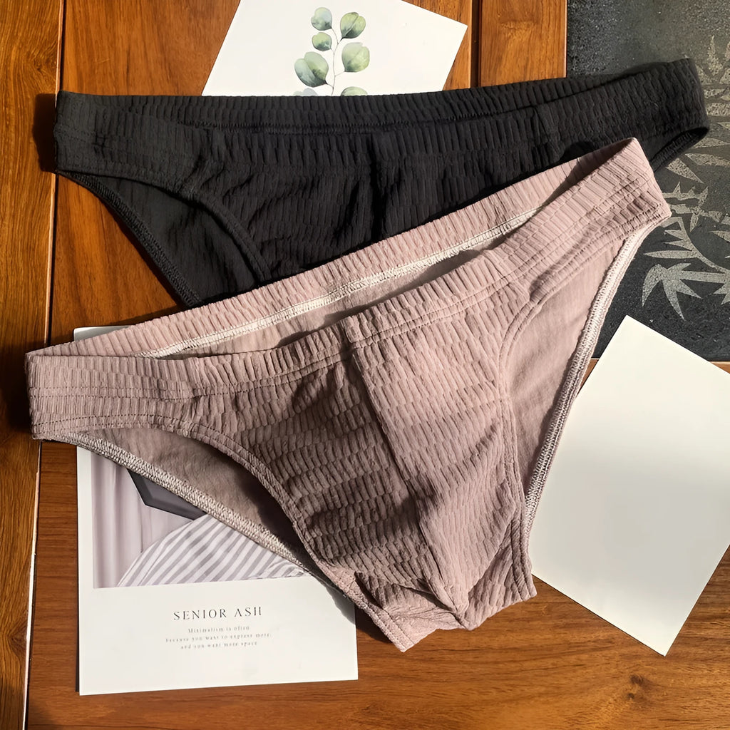 Men's solid colour cotton triangle briefs on a mid-waist, showing apricot, black, white and skin colour options.