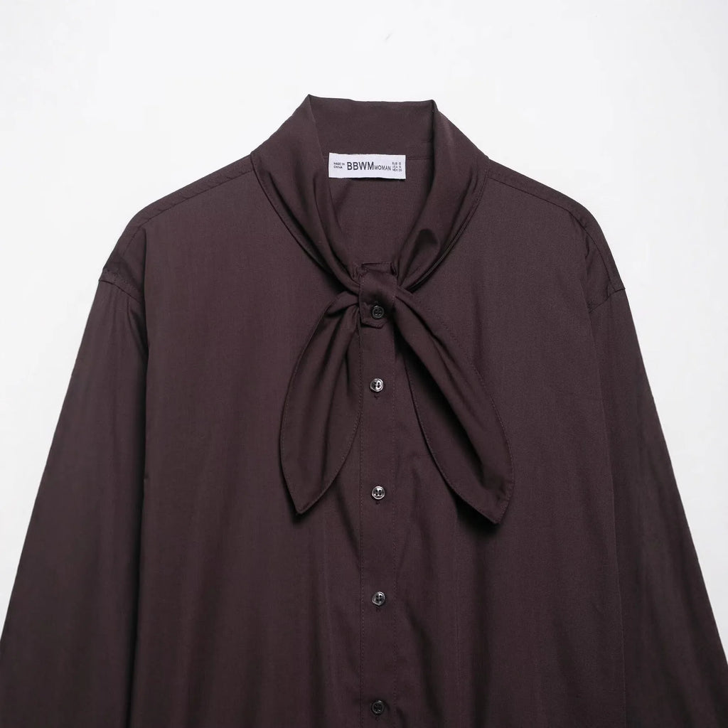 Brown loose-fit women's poplin shirt with long sleeves and a matching bow tie scarf, shown in a cardigan style.