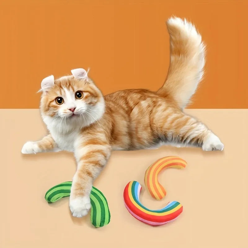 Green, rainbow, and yellow cat toy set with noise maker, catnip strip, and striped plush pillow.