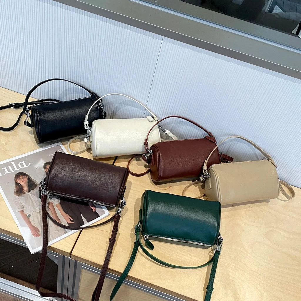Vegetable tanned leather crossbody phone bag in cylindrical shape on a single adjustable strap.