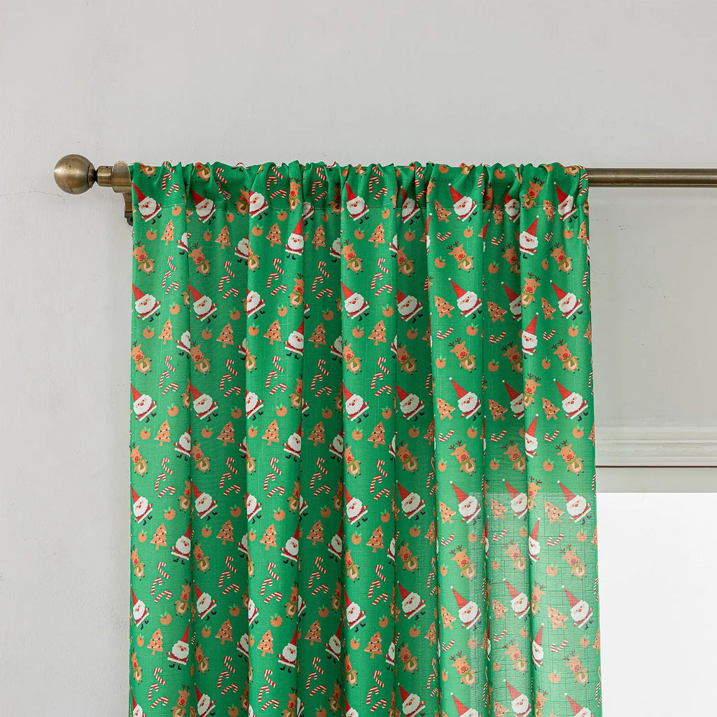 Green festive curtain with printed cartoon snowman and angel pattern.
