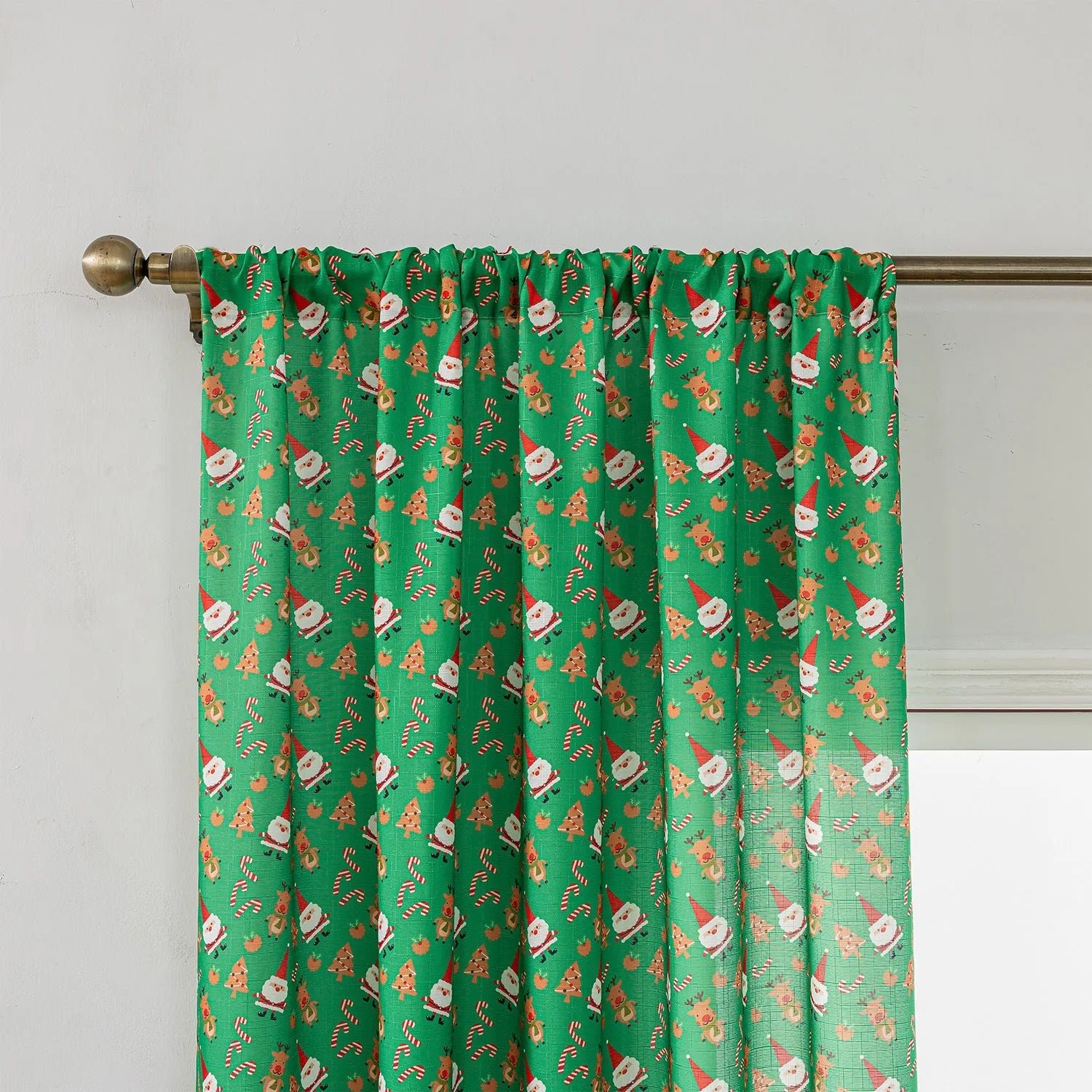 Green festive curtain with printed cartoon snowman and angel pattern.