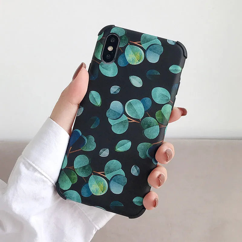 Black silicone iPhone case featuring a decorative leaf print design on the back.