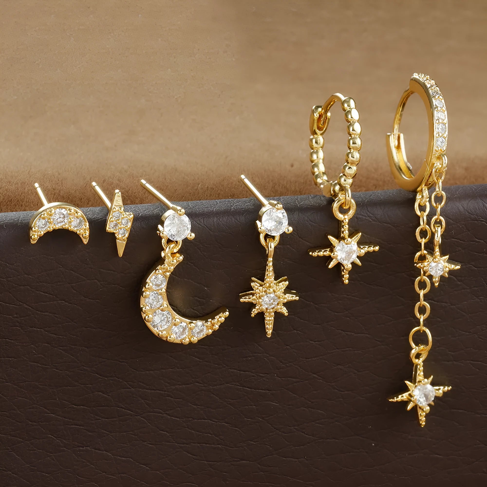 Gold-coloured chain tassel earrings with six dangling elements and zircon stud details on copper construction.