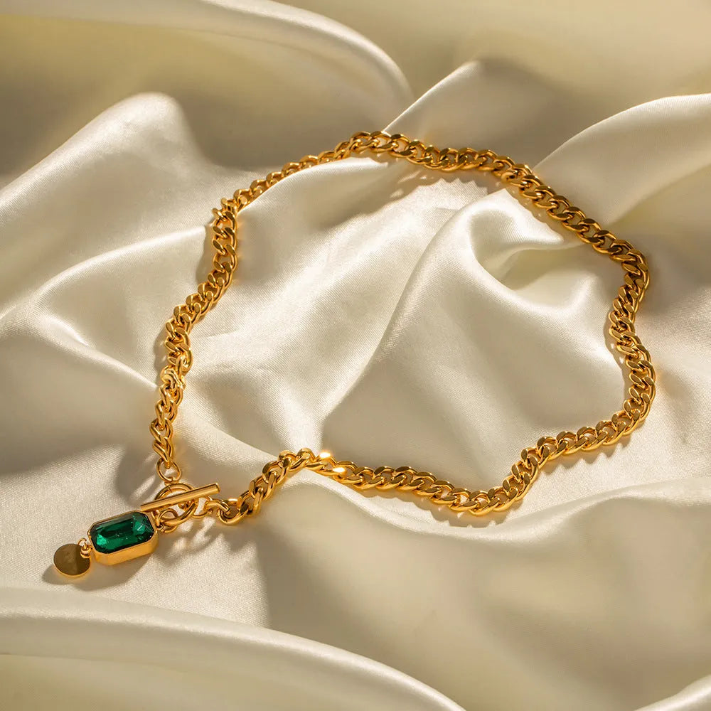 Gold electroplated geometric round pendant necklace with Cuban link chain and emerald zircon detail