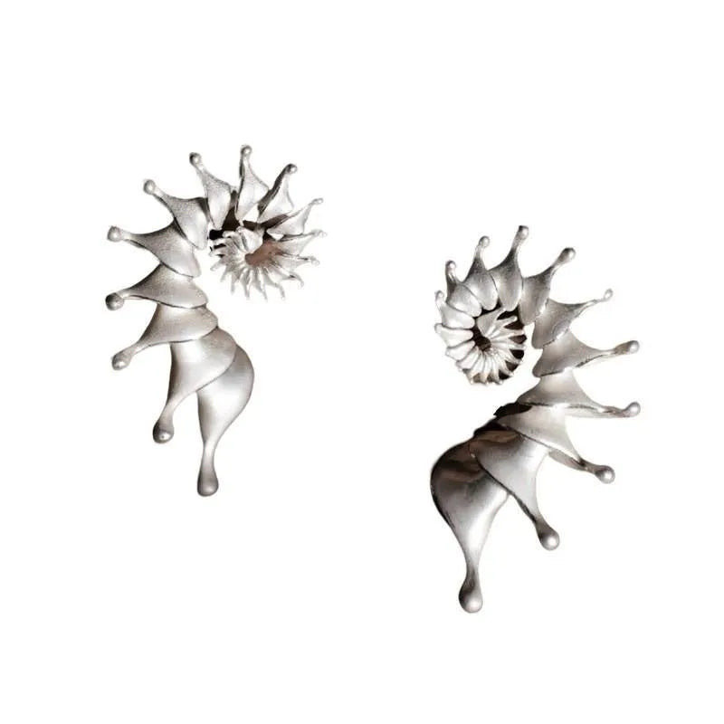 Matte finish three-dimensional conch-shaped alloy drop earrings on a plain background.