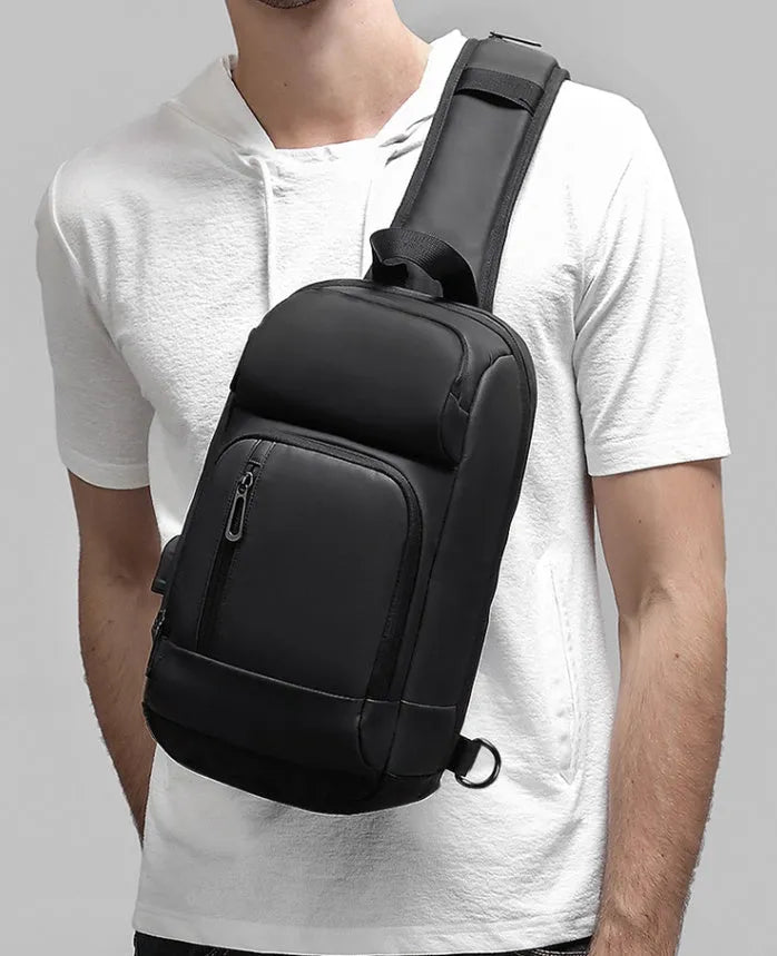 Black medium PVC outdoor shoulder bag showing air cushion strap, soft handle, and internal organiser pockets.