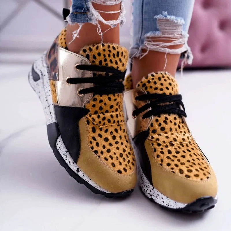 Women's casual flat sneakers in leopard print with suede upper and a low wedge heel.