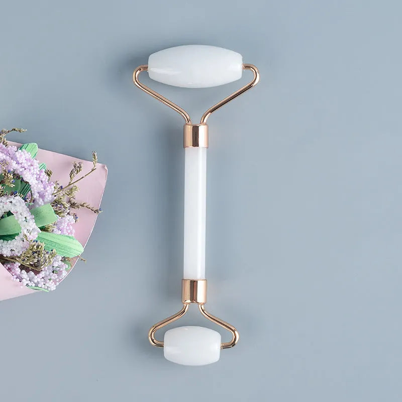White jade facial roller and matching massage board set on a flat surface.