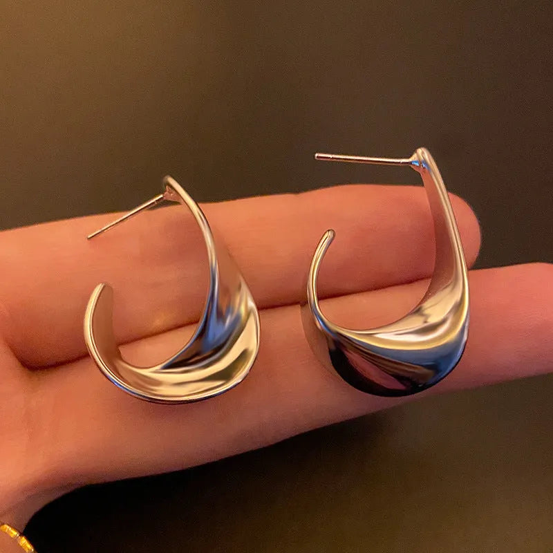 Geometric round metal earrings with twisted design in gold electroplated finish