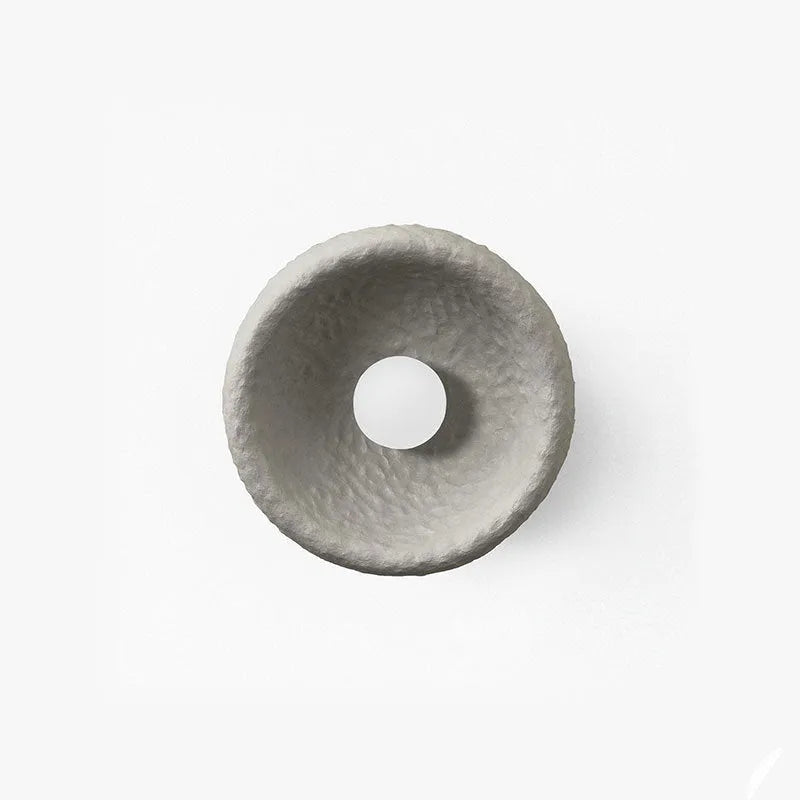 Japanese modern simple wall lamp with white resin shade in three size options on a plain wall.