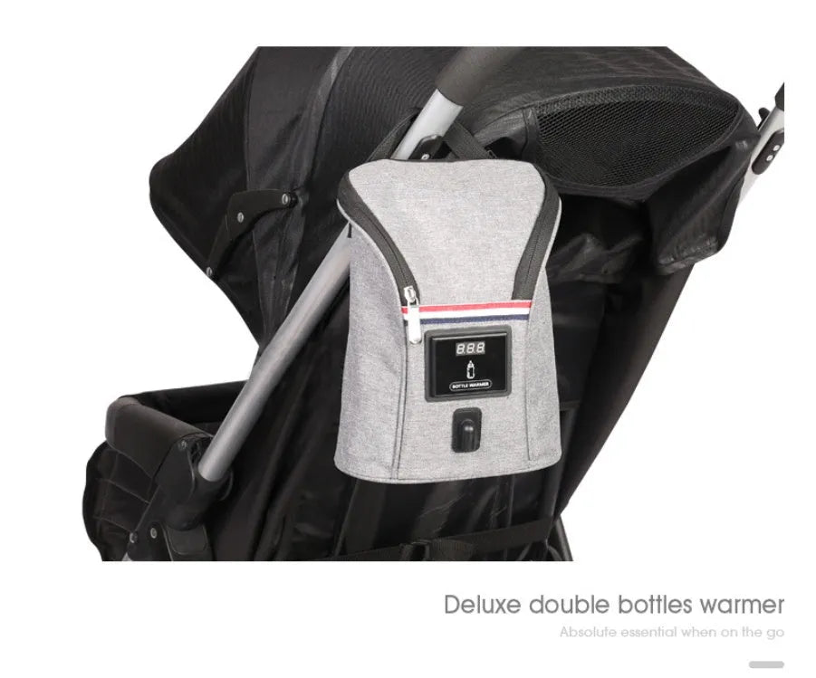 Grey portable car baby bottle warmer with dual slots and digital temperature display screen connected to 12V charger