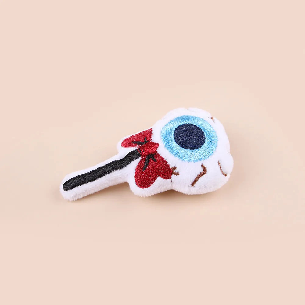 Small plush cat teaser wand with three interchangeable attachments: candy, eyes and skull designs