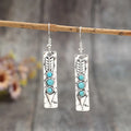Silver geometric drop earrings with turquoise coloured inlays showing retro styling