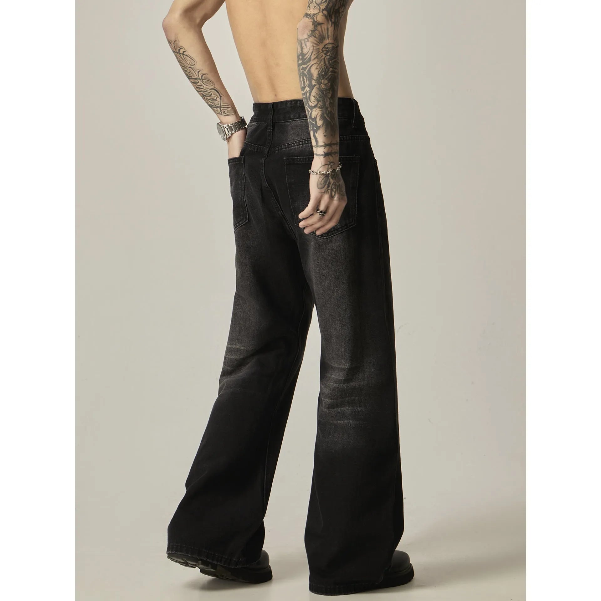 Black loose-fit straight-leg retro jeans with a zip fly on a neutral background.