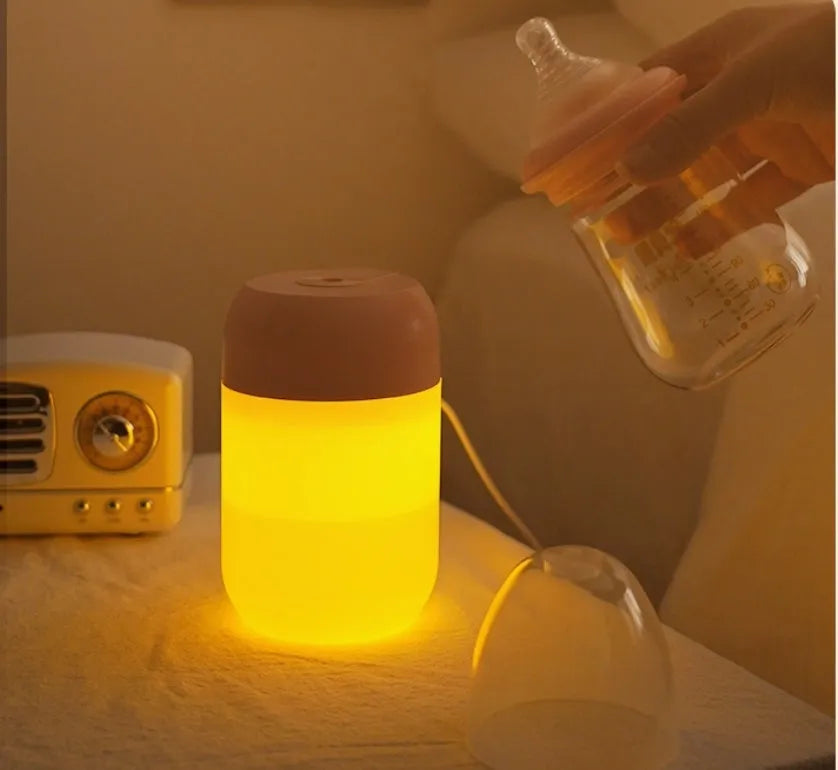 White cylindrical mini humidifier with USB cable on wooden desk