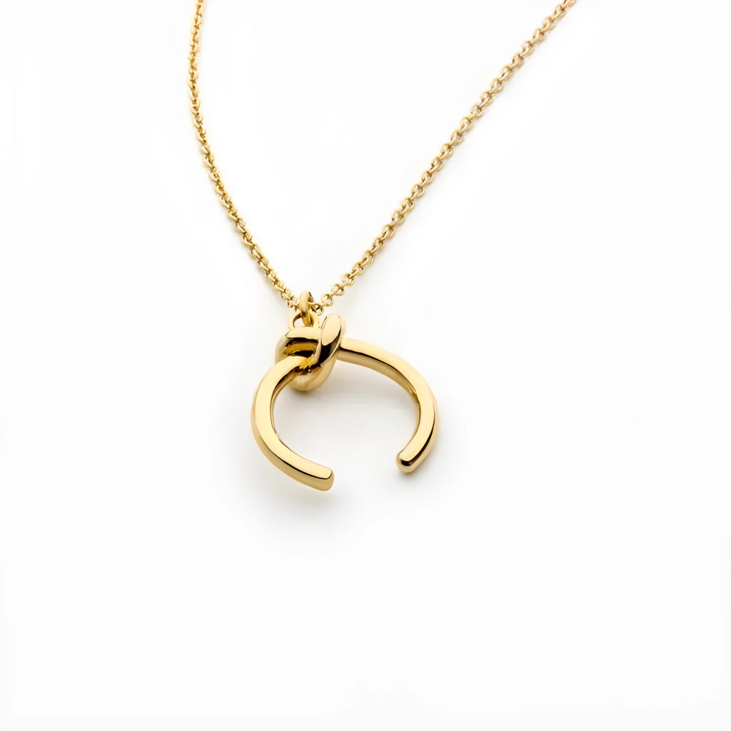Gold geometric pendant necklace on a cross chain with vintage style.