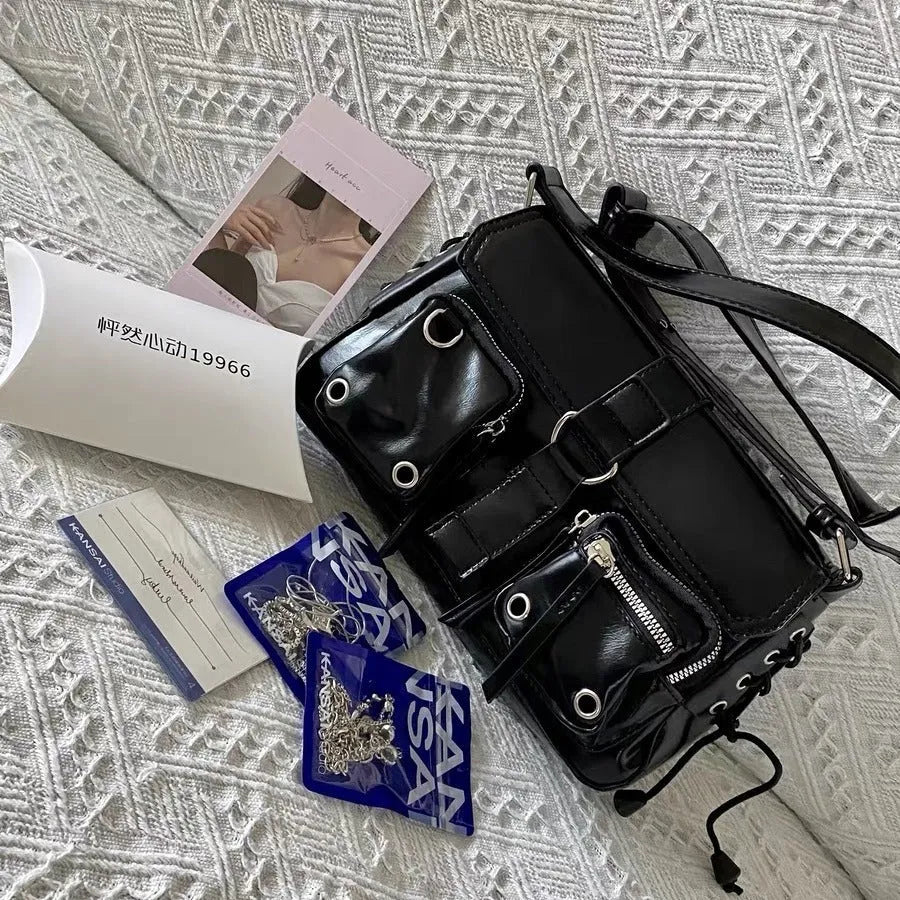 Black PU leather underarm baguette bag with an adjustable long strap.