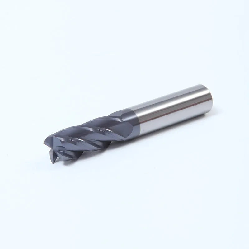 Set of straight shank carbide milling cutters with spiral edges on a workshop bench.