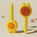 Green pet grooming brush with a release button and stainless steel teeth on a non-slip handle.
