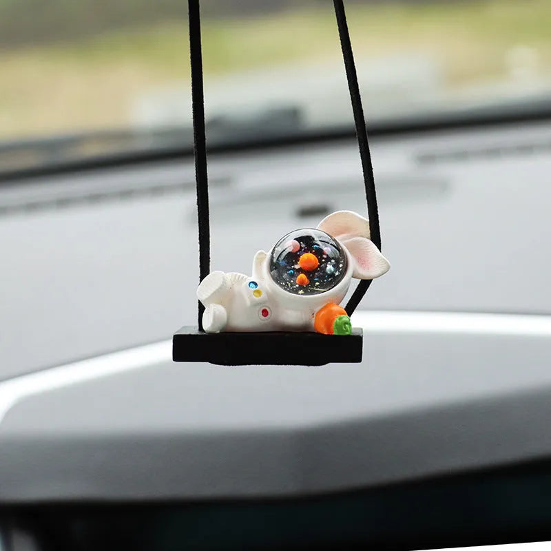 Resin cartoon astronaut car pendant charm in red flag design hanging from a rearview mirror.