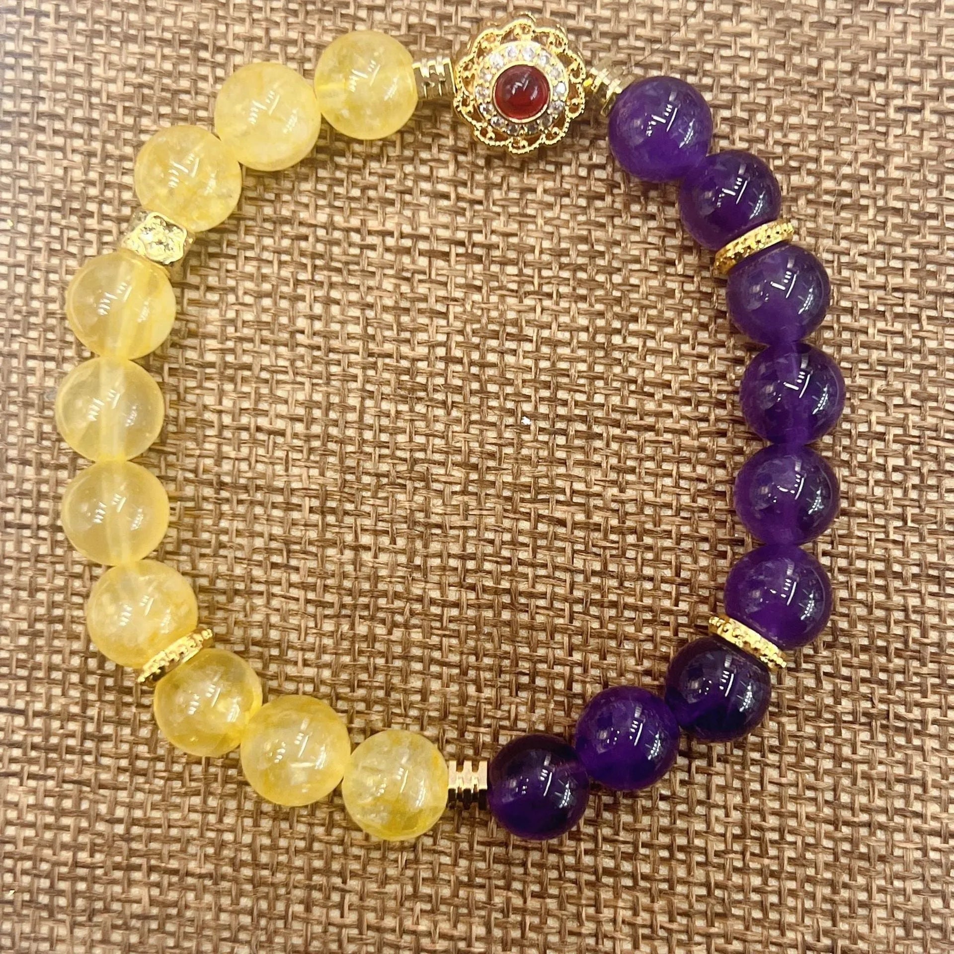 Handmade yellow and purple crystal women's bracelet on wrist.