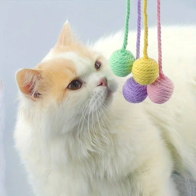 Colourful cat toy ball with an attached rope and an internal bell, shown in green, pink, purple and yellow.