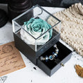 Blue eternal flower rose and carnation bouquet inside a square decorative gift box.