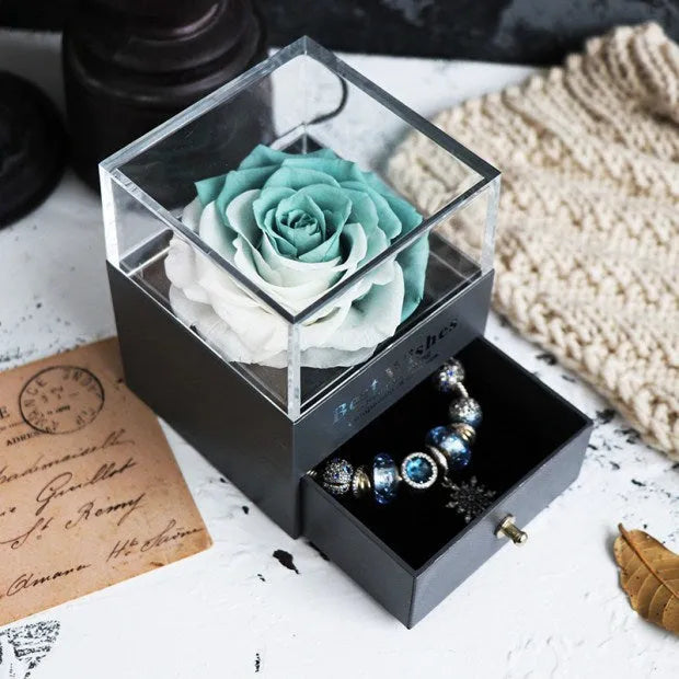 Blue eternal flower rose and carnation bouquet inside a square decorative gift box.