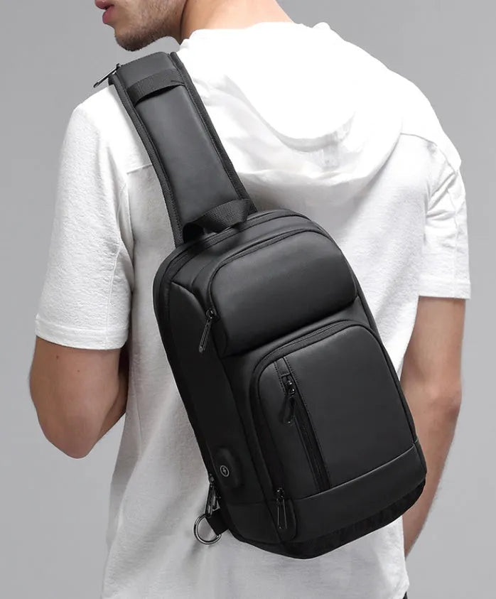 Black medium PVC outdoor shoulder bag showing air cushion strap, soft handle, and internal organiser pockets.