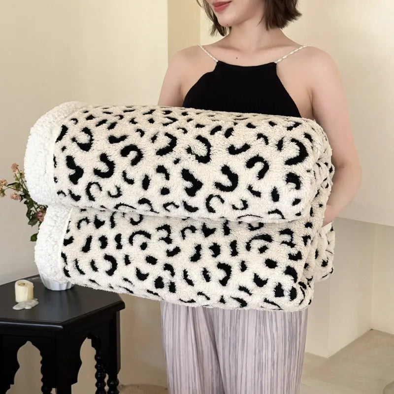 Double-layer jacquard taffeta blanket with leopard print pattern in camel colour on a bed.