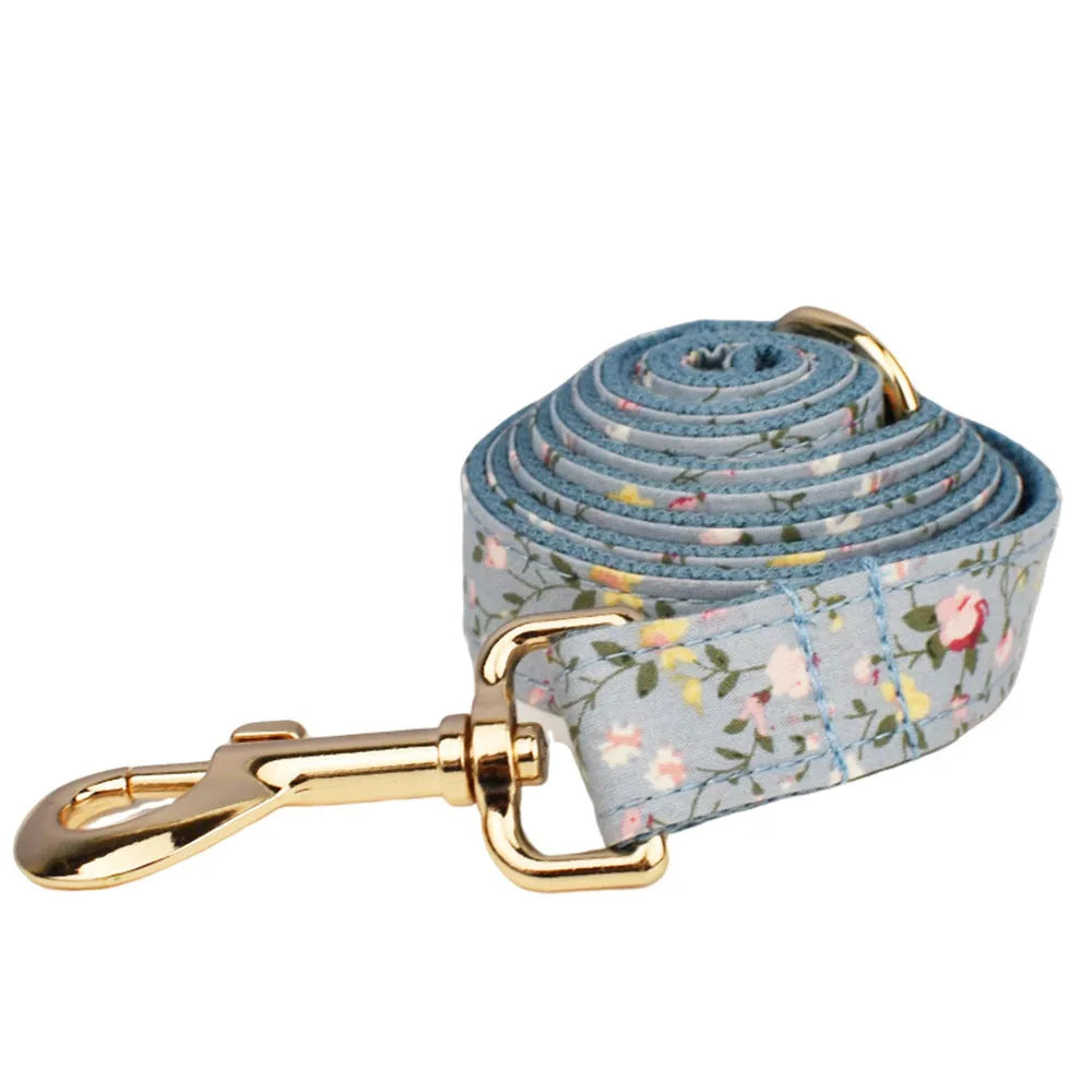 Blue floral patterned cloth dog collar set with matching leash, bow, and vest for small to extra-large dogs.