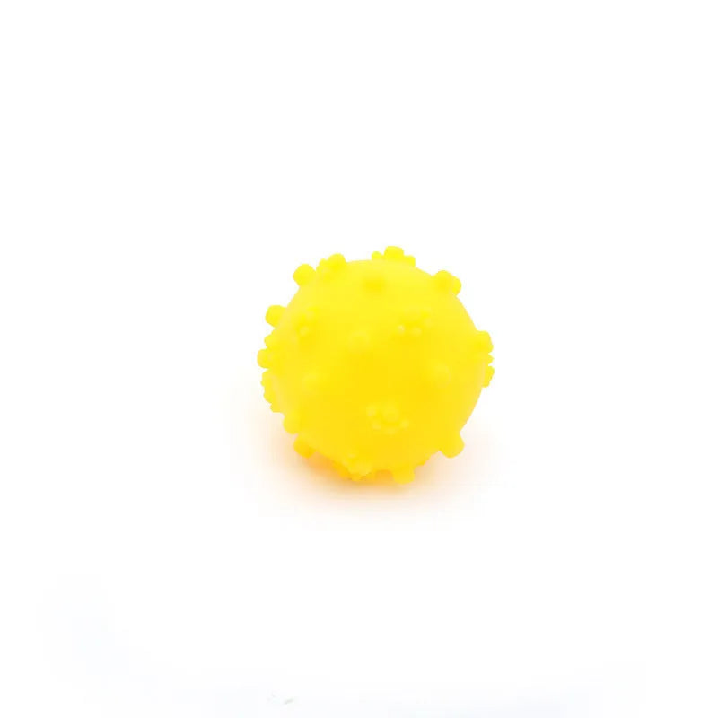 Bright blue, green, pink, and yellow spiky dog toy balls with paw print dimples, shown next to a small dog.
