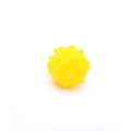 Bright blue, green, pink, and yellow spiky dog toy balls with paw print dimples, shown next to a small dog.