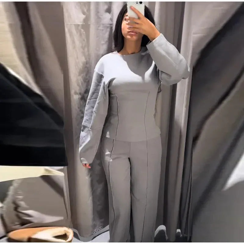 Women's polar fleece suit set with long sleeve O-neck top and wide leg pleated trousers in black.