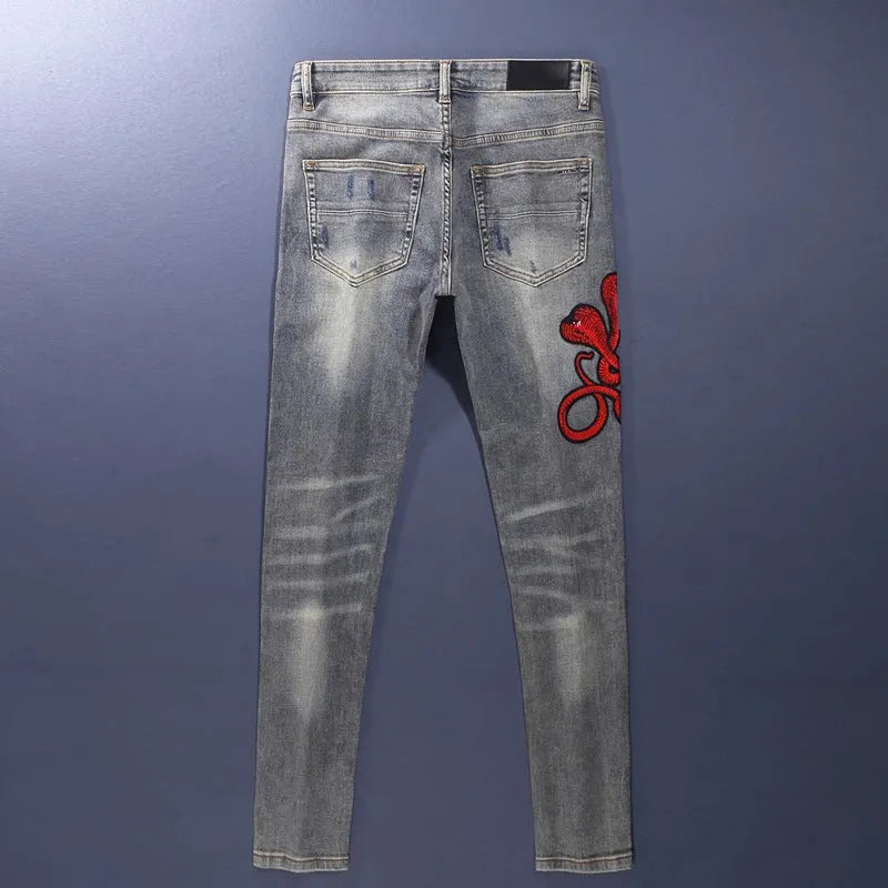 Men's slim fit jeans in a washed-out old colour with distressed hole and patch details on the legs.