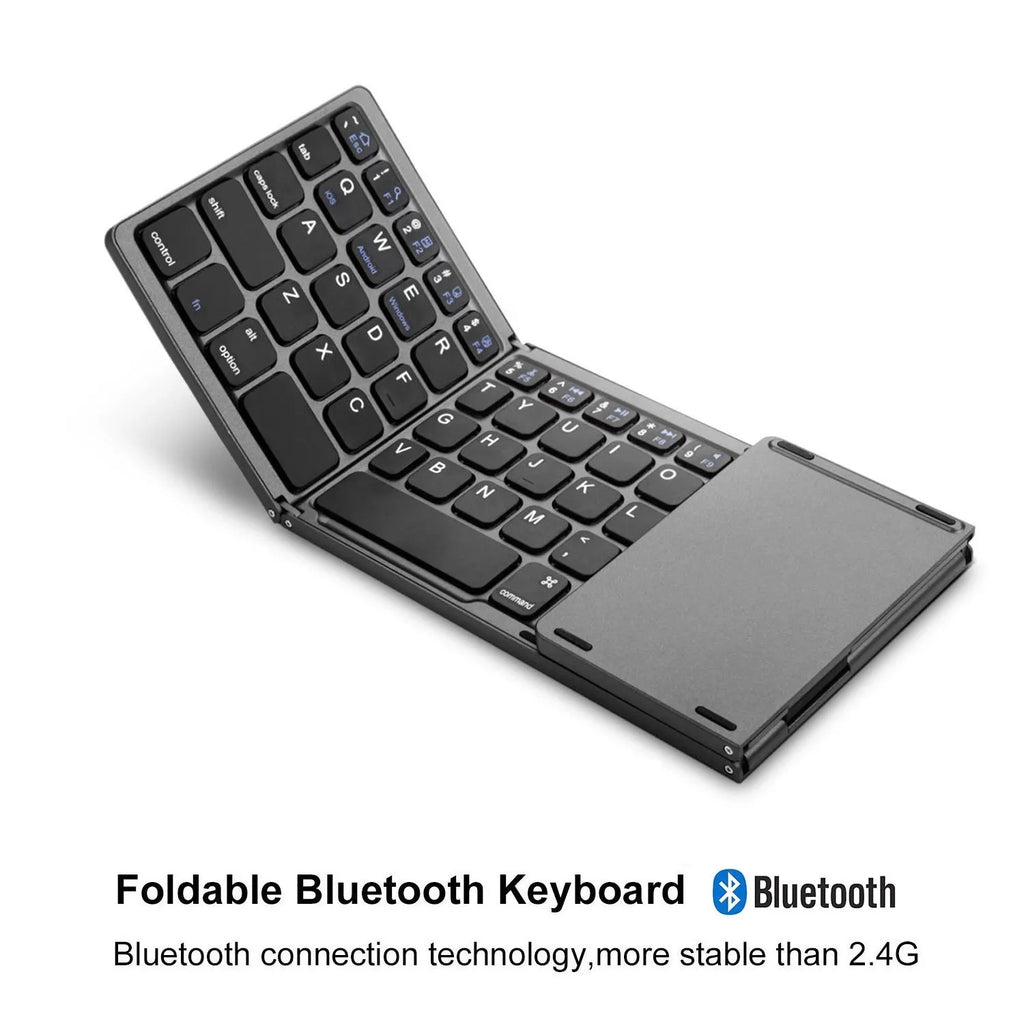 Black mini tri-fold Bluetooth keyboard unfolded next to a tablet, showing its compact size.