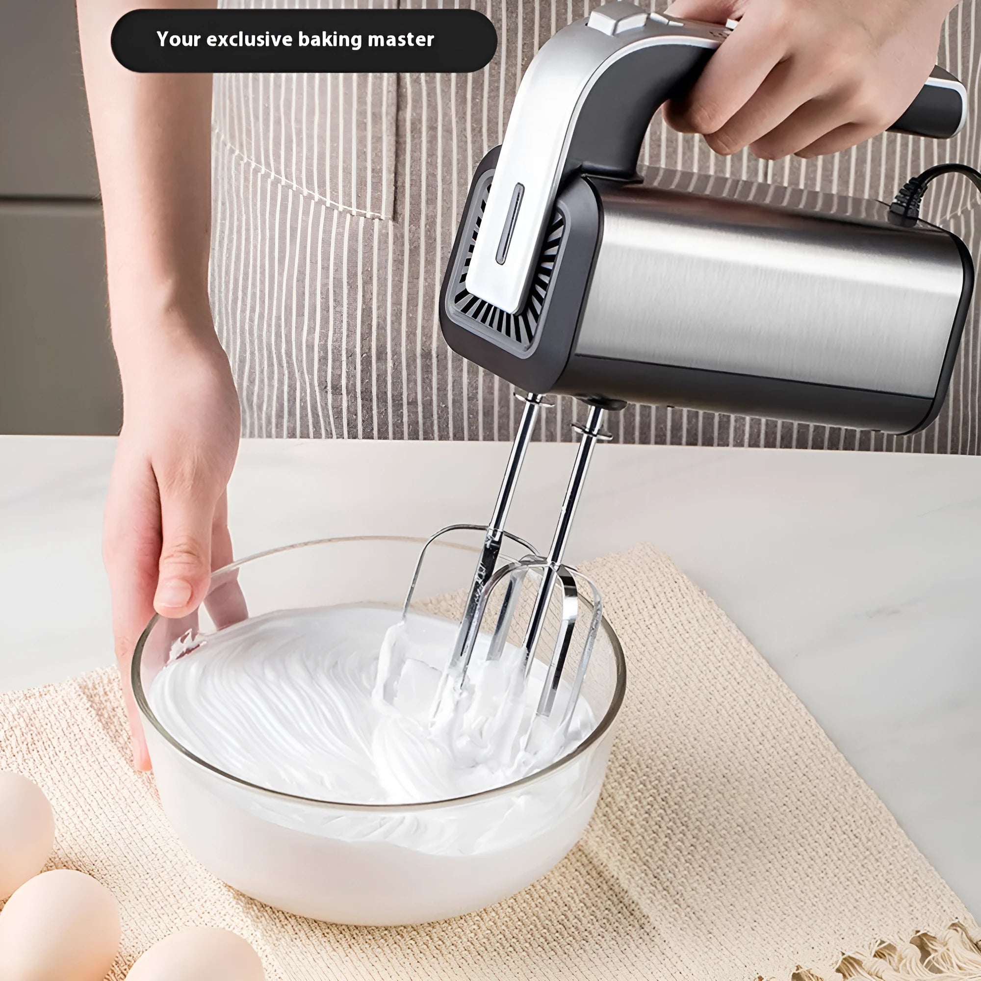 Silver handheld electric mini whisk with stainless steel beaters and five-speed control dial.