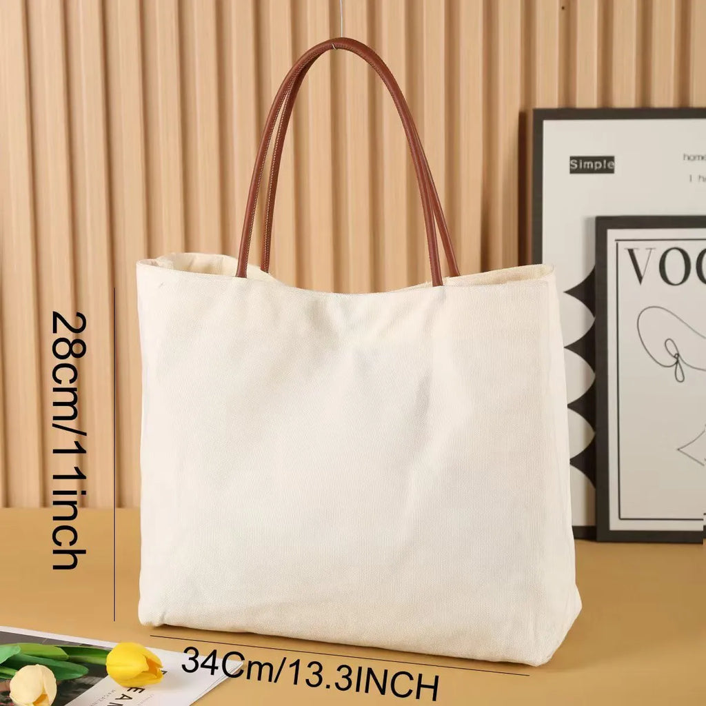 Beige white cotton canvas tote bag with sturdy handles on a plain background.