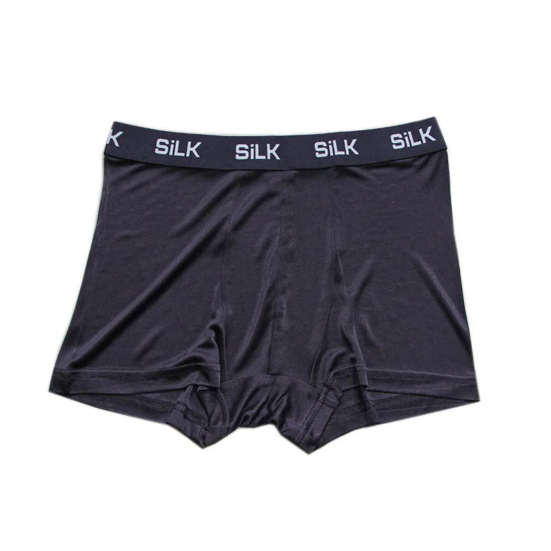 Man wearing loose fit silk shorts in navy blue colour for casual summer wear.